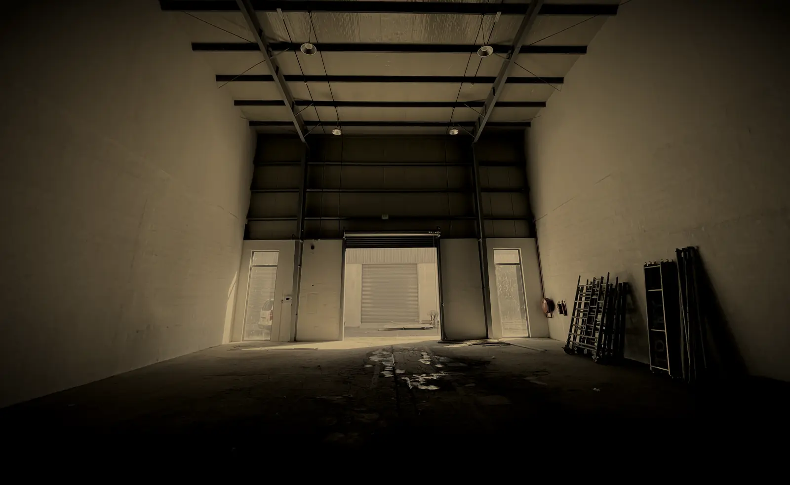 Inside an empty warehouse in Al Quoz Industrial 4, Dubai, looking out through the open roller shutter