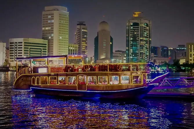 A dhow lit for a dinner cruise on Dubai Creek at night